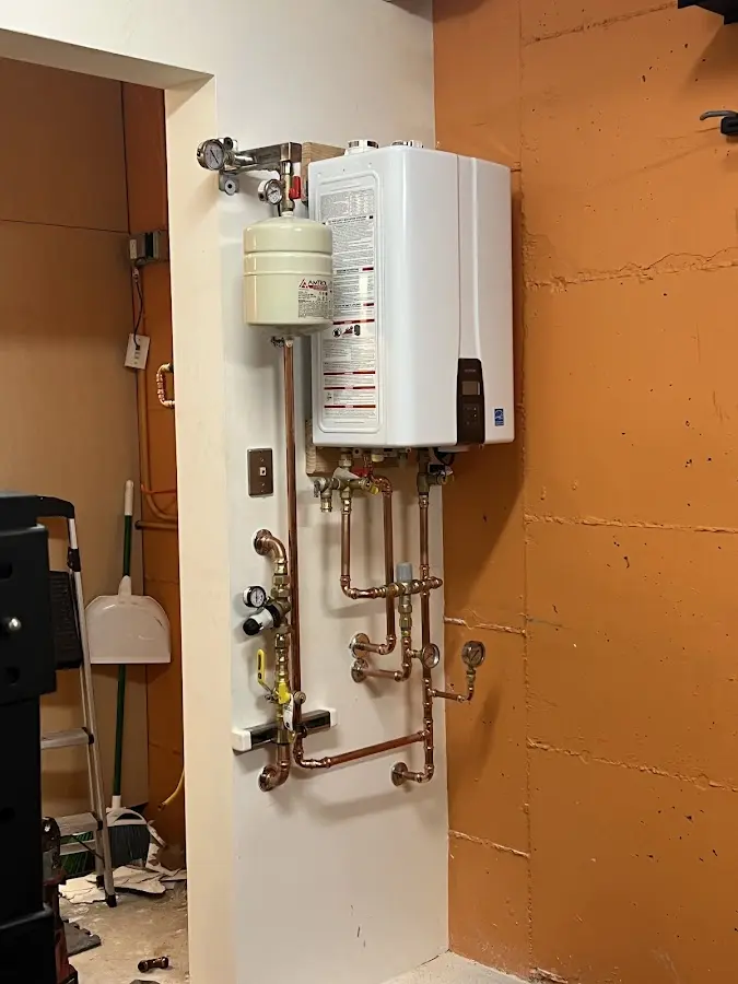 Plumbing technician inspecting water heater connections in Chickamauga